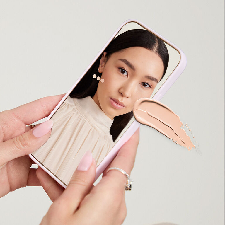 Fair-skinned hands holding a cell phone showing a woman