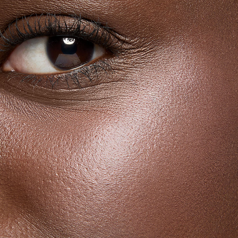 Model with deep skin wearing gel blush on her cheek